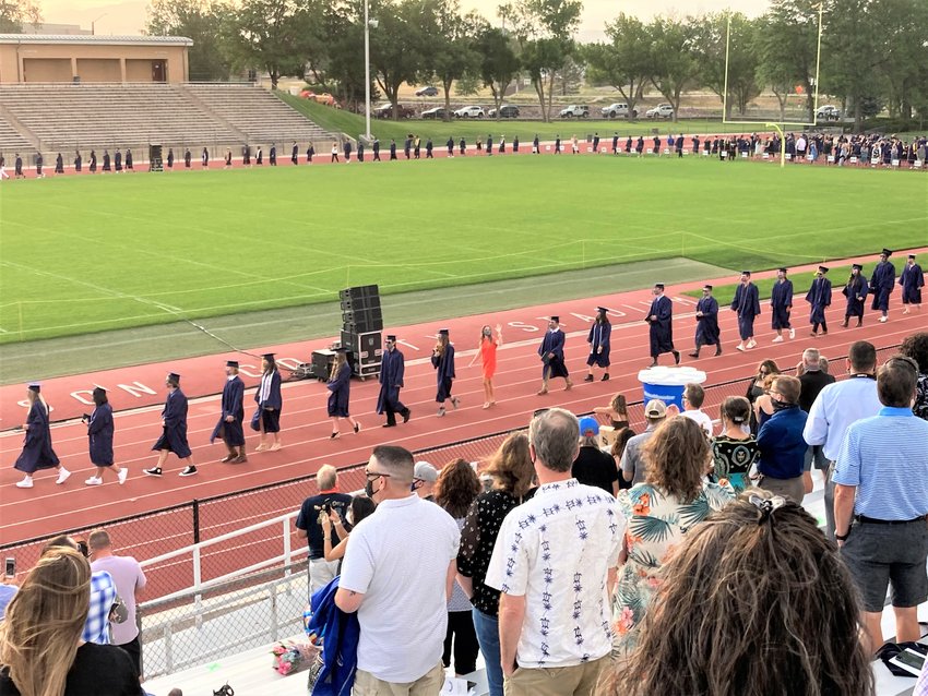 A man excitedly points toward the graduates entering Jeffco Stadium during Columbine High School's graduation on Aug. 4, 2020.